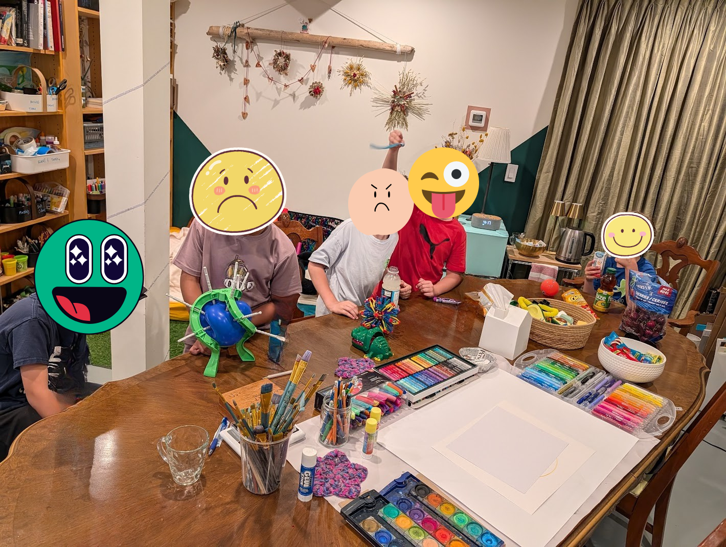 Group art therapy at TATS. image of children at a therapy table playing games, having snacks, making art